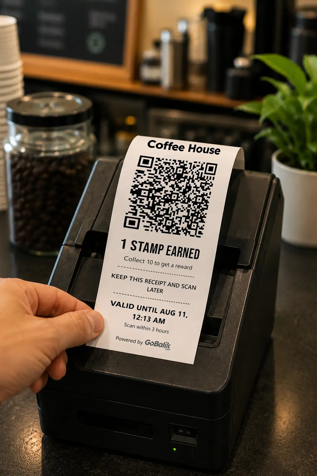A printed loyalty receipt with a scannable QR code and stamp count, held over a coffee shop receipt printer